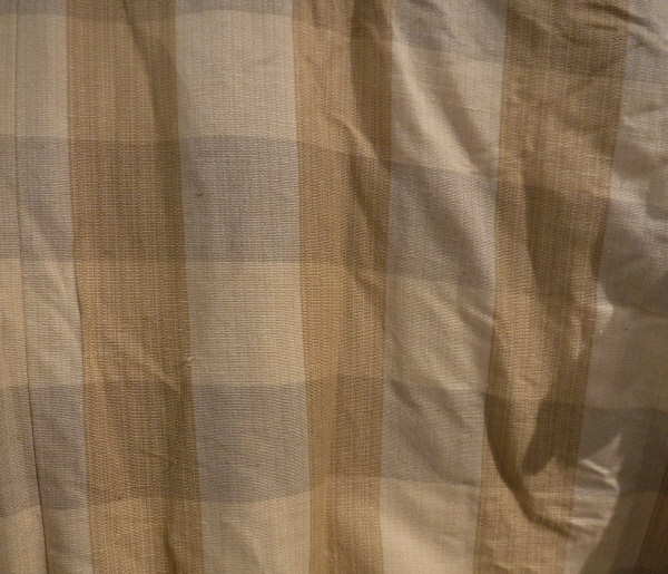 A pair of cotton interlined curtains of gold checked design and a further curtain together with a