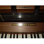 A Henry Riley & Sons mahogany cased upright piano with iron framed overstrung movement