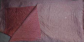 A vintage quilt of plain pink colour