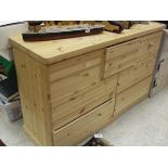 A modern pine chest of three short over a bank of four drawers on a bracket foot base