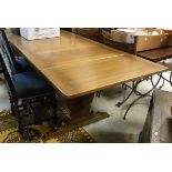 A modern elm drawer leaf dining table on end trestle supports united by a centre stretcher