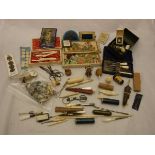 A box containing assorted sewing accoutrements to include needle cases, buttons and thimbles,