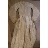 A mid Victorian cream moire silk wedding dress with ribbon and net detail,