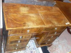 A walnut and feather-banded kneehole desk in the 18th Century manner,