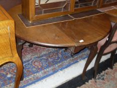 A late George III mahogany oval drop-leaf dining table on cabriole legs to pad feet,