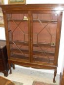 A 20th Century mahogany display cabinet with moulded pediment, two astragal glazed doors,