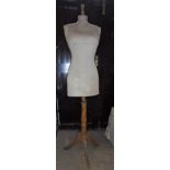 A vintage dressmaker's dummy on wooden stand