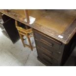 A 20th Century oak desk with brown inset top, the pedestals each containing four drawers,
