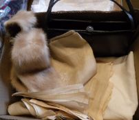 A box containing a mink tippet, black leather handbag,