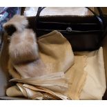 A box containing a mink tippet, black leather handbag,
