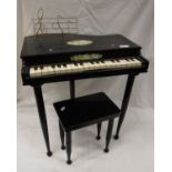 A child's "baby grand piano" and stool in black lacquered case