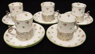 A set of five decorated porcelain coffee cans with silver pierced scrolling foliate cherubic