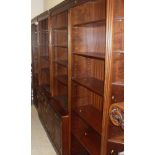 A large reproduction mahogany lounge display unit consisting of two central sections of shelves
