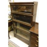 An oak four section Globe Wernicke bookcase with two ivorine labels to the back, one marked "D.T.