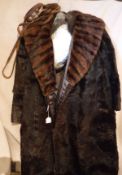 A brown fur coat with mink trim and a bag containing various bags,