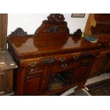 A late Victorian carved cherrywood sideboard,