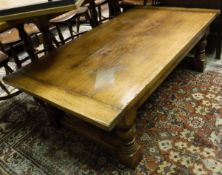 An oak coffee table in the 17th Century manner raised on turned legs to block feet united by a