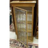 A pine wall-hanging display cabinet with a leaded glazed door enclosing shelves,