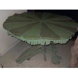 A green painted shaped segmented top centre table with a driftwood base