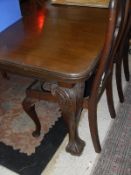 An early 20th Century mahogany rectangular dining table on carved cabriole legs to claw and ball