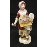 A 19th Century Volkstedt figure of a flower seller bearing blue crossed hay forks marks and