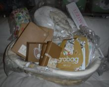 An Izzi Wotnot moses basket with stand, various gro bag baby sleeping bags, an Ella & Otto playmat,