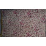 An early 20th Century quilt with pink and cream floral and paisley decoration to the front and