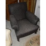 A circa 1900 upholstered scroll armchair on cabriole front legs to pad feet and castors,