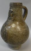 A 17th Century Bellarmine jug of typical form with mask decoration over a heraldic shield depicting