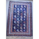 A Persian carpet, the central panel set with repeating hook motifs on a blue ground,