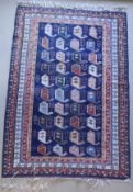 A Persian carpet, the central panel set with repeating hook motifs on a blue ground,