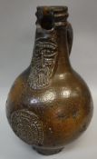 A 17th Century Bellarmine jug of typical form with mask decoration over a roundel medallion