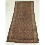 A Persian carpet, the central panel set with all over repeating floral design on a red ground,