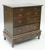 An 18th Century oak chest on stand with applied moulded pediment over a base of two over three