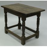 An 18th Century oak centre table, the three plank top over a scrolling foliate carved frieze,