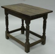 An 18th Century oak centre table, the three plank top over a scrolling foliate carved frieze,