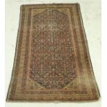 A Persian rug, the central panel with all over floral decoration on a dark blue ground,