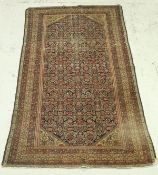 A Persian rug, the central panel with all over floral decoration on a dark blue ground,