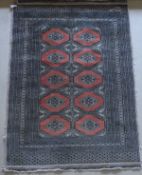 A modern Persian rug with repeating medallion pattern on a salmon pink ground,