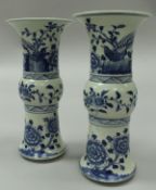 A near-matching pair of Chinese blue and white porcelain Gu beaker vases in the Kangxi manner with