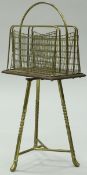 A Victorian brass and oak revolving magazine rack on tripod base,