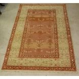 An Agra rug, the central panel with variegated pink ground decorated with flowers,