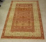 An Agra rug, the central panel with variegated pink ground decorated with flowers,