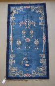 A Chinese rug, the central panel set with decorative lantern and floral design on a blue ground,