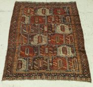 A circa 1900 Persian rug with repeating leaf decoration on a blue and red ground,