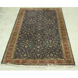 A Persian carpet, the central panel set with all over floral decoration on a blue ground,