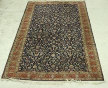 A Persian carpet, the central panel set with all over floral decoration on a blue ground,