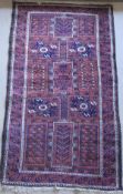 A Beluch prayer rug, the red ground with all over panel decoration,