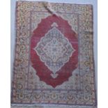 A Turkish rug, the central panel set with floral decorated medallion on a plain red ground,