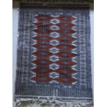 A modern Persian rug with repeating medallion decoration on a rust ground,